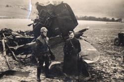Two young soldiers standing in front of metal structure.