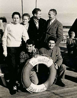 Several young people standing behind a lifesaver reading SS Homeric.