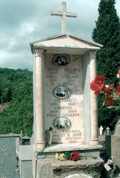 Family plot in a cemetery with big tombstone and lots of trees in the background.
