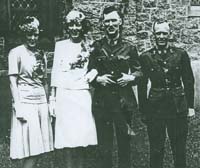 Newlyweds in front of the church with a man and a woman on each side.