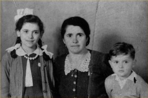 Maria, daughter with ribbons in hair on one side, young son on other side.