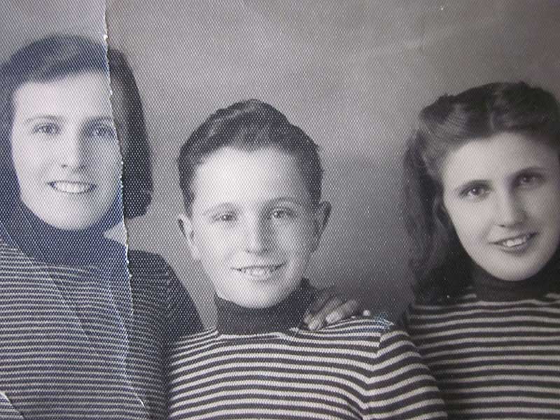 Old cracked photo of a woman and child, a second child is cut off from view.