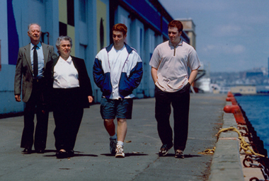 Marianne and husband, walking on waterfront with two grandsons in summer.