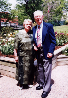 Marianne and husband, with beautiful gardens in background.