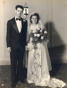Bride and groom on wedding day, bride carries huge bouquet of flowers.