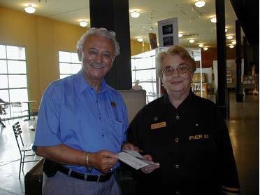 Marianne in a black shirt at Pier 21, standing with a man in the Reception Pavilion.