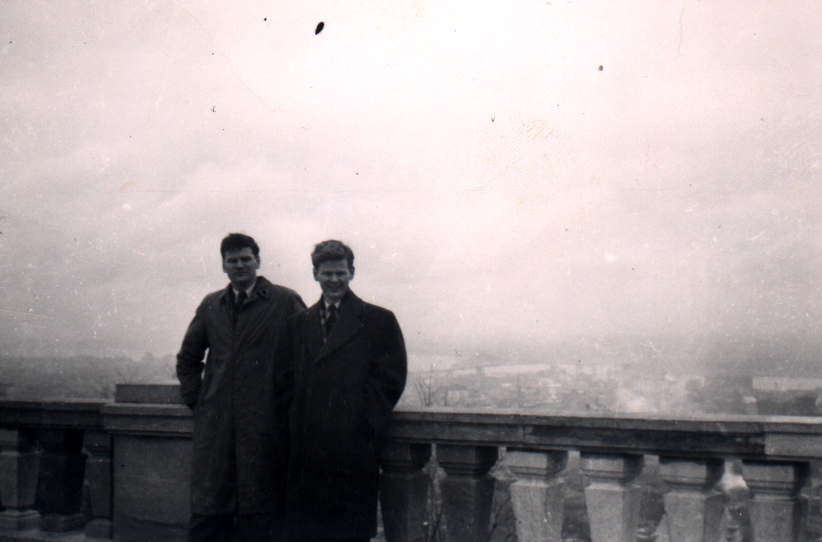 Old photo of two young men in dark suits.
