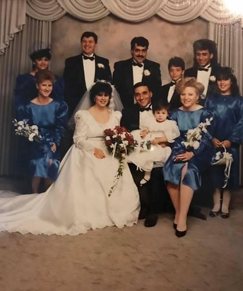 Happy bride and groom surrounded by their families.