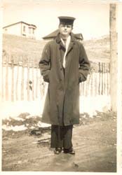 Young man in overcoat and sailor's cap.