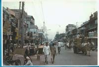Busy street of Delhi with people and horse-drawn cart.