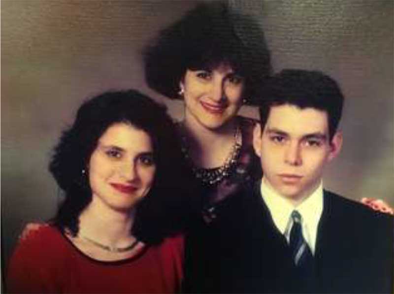 Colourful family portrait of two sisters and a brother, well-dressed