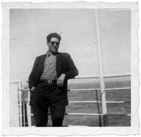Peter leaning against the railings of the ship, with ocean behind him.