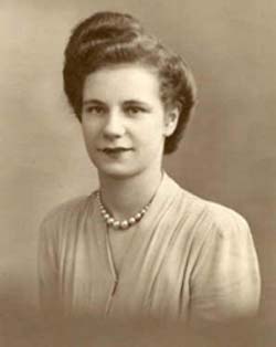 Sepia-toned portrait of young woman wearing light-colored dress and pearls..