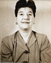 Head and shoulders shot of Sadie, with hair up wearing gold earrings.