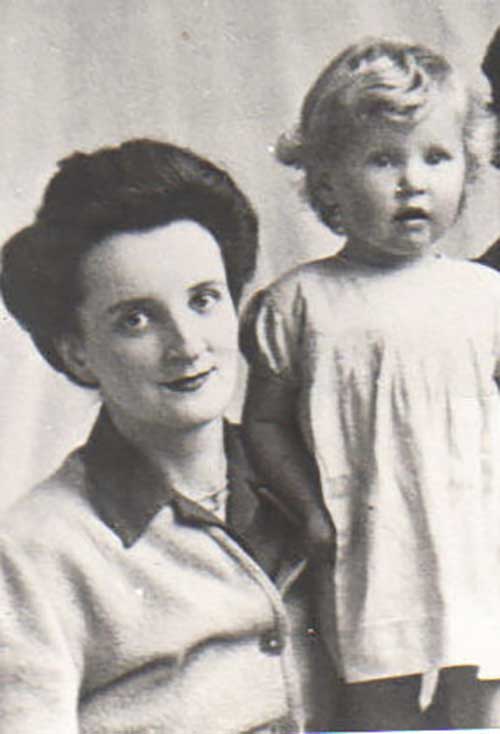 A woman sits with a small child in her lap.