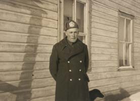 Young Harold in a winter coat, standing in front of a building.