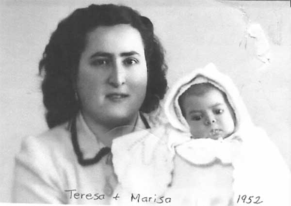Young mother and small baby, both dressed in white.