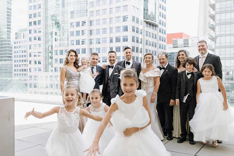 Little girls in white run towards the camera as the adults look on in the background.