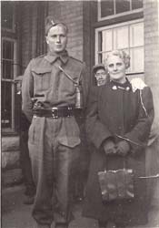 Young man in uniform, standing next to woman holding purse.