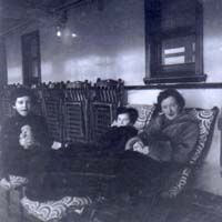 Woman seated with two children on deck chairs aboard the ship, Scythia.