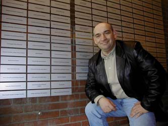 Tarcisio standing next to his plaque on the Sobey Wall of Honour, Pier 21
