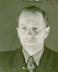 Close-up of Janis' face, young man, wearing a dark suit and tie.
