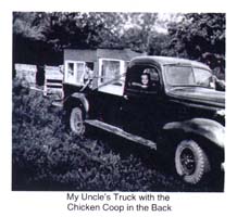 Boy sitting on the passenger side of an old truck and hen cage in the back.