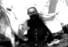 Obscured photograph showing a woman in front of a white area.