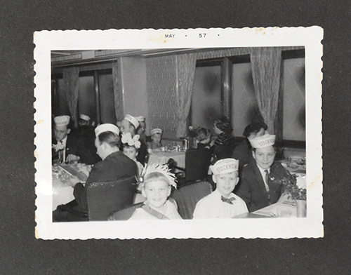 Black and white photo of Denmark family wearing caps, three kids are sitting for photo.