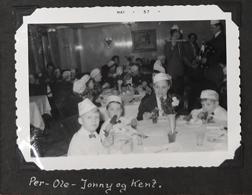 Black and white photo of three kids and one beautiful lady sitting with them and holding ice cream in hands.