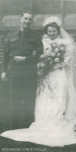 Bride and groom on wedding day, bride with veil and huge bouquet.