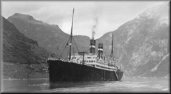 The ship, Volendam, in port with hills in background.