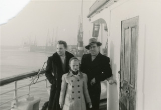 Black and white photo of a man, woman and a child on a ship.