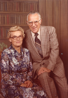 A man and a woman sitting down posing for a photo.